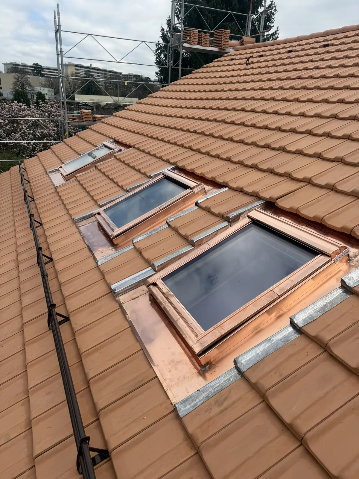 Fenêtres de toit habillées de zinc dans une couverture en tuiles.